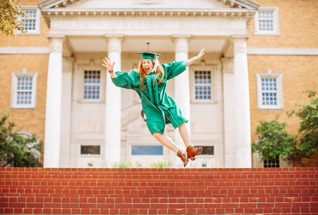 woman jumping above stairs wearing graduation gown and a hat 2335298